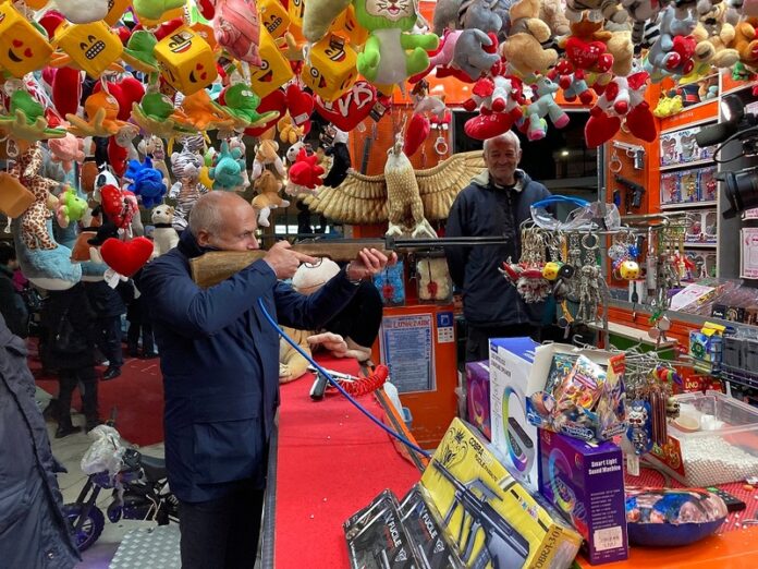 il Sindaco Franz Caruso ai mercatini di Natale mentre scherza al tiro a segno
