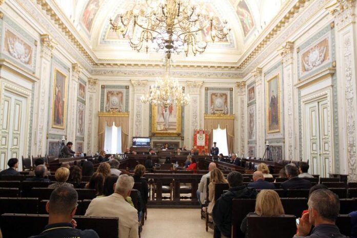 Nella mattinata di giovedì 22 maggio, il Consiglio ha approvato il Conto Consuntivo 2024 della Provincia di Cosenza, chiuso con un disavanzo di 82 milioni che, aveva già spiegato ai Consiglieri provinciali la Presidente Rosaria Succurro, «derivano dagli effetti della legge Delrio e da vecchi mutui, sottoscritti dall’amministrazione di Mario Oliverio, che ingessano il bilancio dell’ente al punto che risulta difficile anche provvedere agli interventi ordinari come il taglio dell’erba». «È quindi necessaria un’operazione di verità – ha più volte detto Succurro – per liberare il campo da menzogne, equivoci e fantasie». Nel suo intervento in Consiglio provinciale, la Presidente della Provincia di Cosenza ha dato tre notizie clamorose. La prima: l’ente intermedio ha da poco fatto causa alla Regione Calabria, benché sia dello stesso colore politico, per recuperare 38 milioni di crediti del passato mai riscossi, mentre da ultimo la Regione ha versato alla Provincia di Cosenza circa 4 milioni di euro, che hanno permesso di evitarne il dissesto finanziario, e risolto – ha chiarito Succurro – l’annosa questione dell’immobile di Vaglio Lise, occupato ma a lungo non pagato per metà dall’amministrazione regionale. La seconda: la Provincia di Cosenza ha ereditato dalla gestione Oliverio, «la stessa che in passato aveva ricevuto l’Oscar per il bilancio», un gravame di 30 milioni relativo al Fondo di anticipazione liquidità e 2 milioni all’anno di mutui con il Credito sportivo, nel tempo arrivati alla cifra monstre di 22 milioni di euro. «Ulteriori tagli alla finanza pubblica – ha precisato Succurro – hanno aggravato la situazione. Ma, dopo aver levato la polvere nascosta per tanto tempo sotto il tappeto e in seguito ai continui confronti con dirigenti di vertice della Corte dei conti e dei ministeri coinvolti, siamo certi di poter presentare un Piano di riequilibrio veritiero e credibile che – ha concluso la Presidente – permetterà alla Provincia di Cosenza di tornare agli antichi fasti».